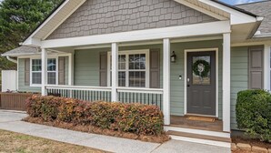 A house with a covered porch, a front door with a wreath, and a small step leading up to the entrance. - Peaceful Rydal Retreat With Modern Comforts (Rydal)
