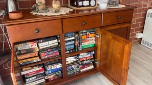 A wooden cabinet with multiple drawers and shelves filled with books. - Hilltop Haven Adelaide Hills Retreat Pet Friendly with Night and Day Yards (Mylor)