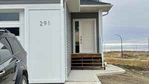 Una casa de dos pisos con fachada blanca, número 291.