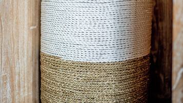 A woven basket with a handle, placed against a wooden background.
