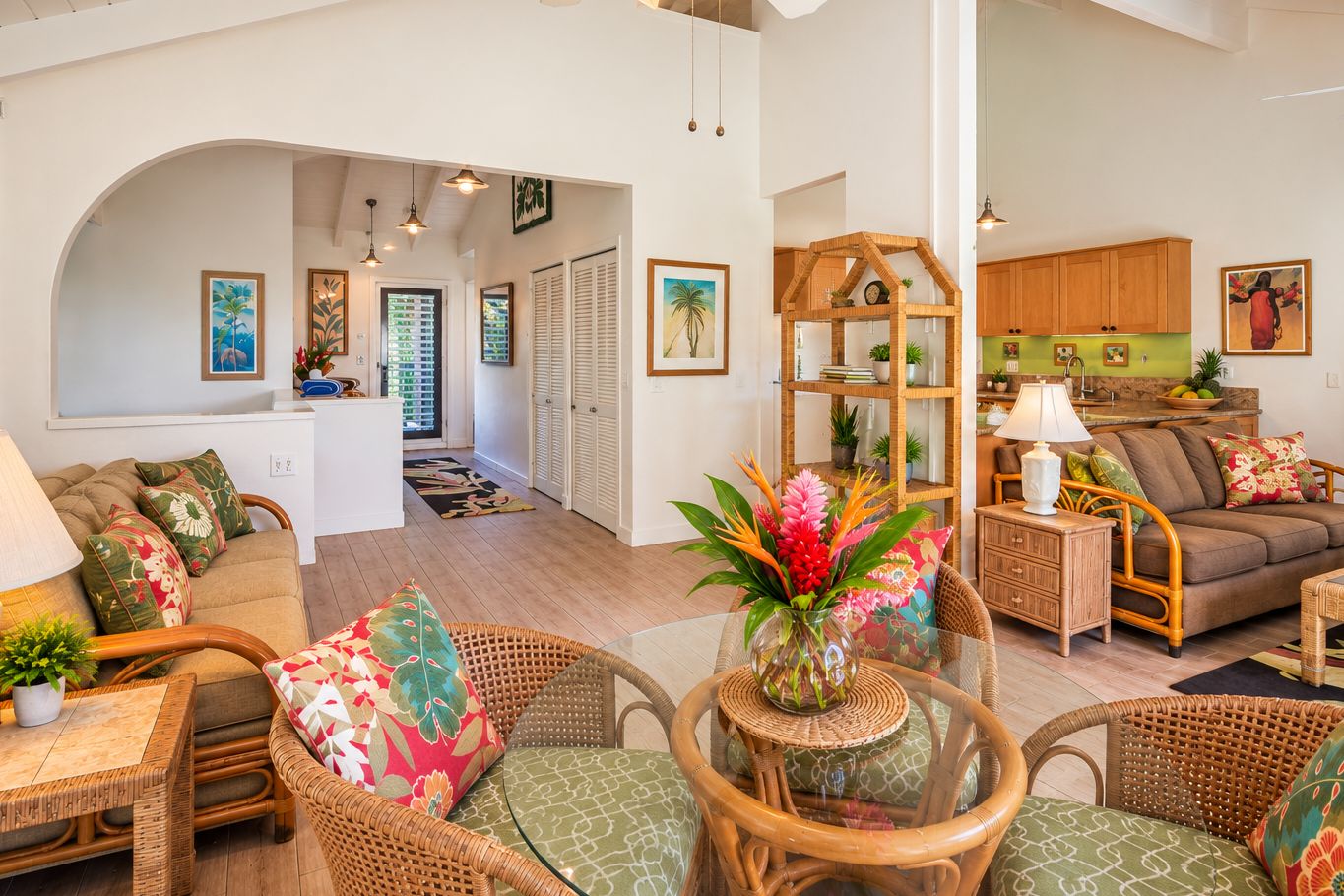 A spacious living area with a sofa, wicker chairs, a dining table, and a kitchen in the background.