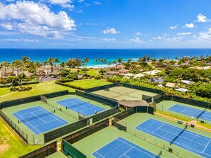 A tennis court complex with multiple courts, a pool, and a view of the ocean. - Kahala 723 “Apana O Lani” – 2 Lanais, King Bed, Island Serenity (Koloa)