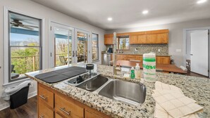 Eine moderne Küche mit Granit-Arbeitsplatten, Edelstahlgeräten und Holzschränken.