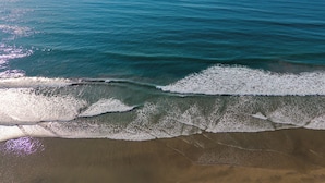 Ein Strand mit an die Küste treibenden Wellen.