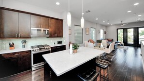 Una cocina moderna con armarios de madera oscura, electrodomésticos de acero inoxidable y una isla central con asientos.