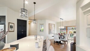 A modern kitchen with a large island, pendant lights, and a dining area with chairs and a table. - Experience luxury at Sedona Willow Villa—spacious 3BR home with stunning Red Rock views! (Sedona)