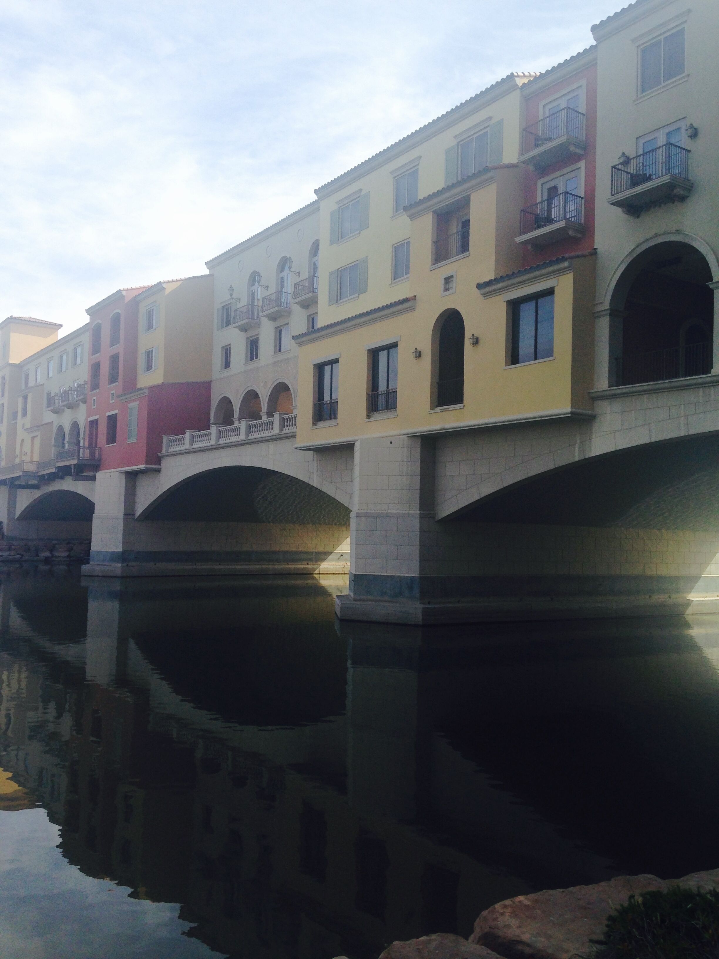 A canal with buildings reflecting on the water.