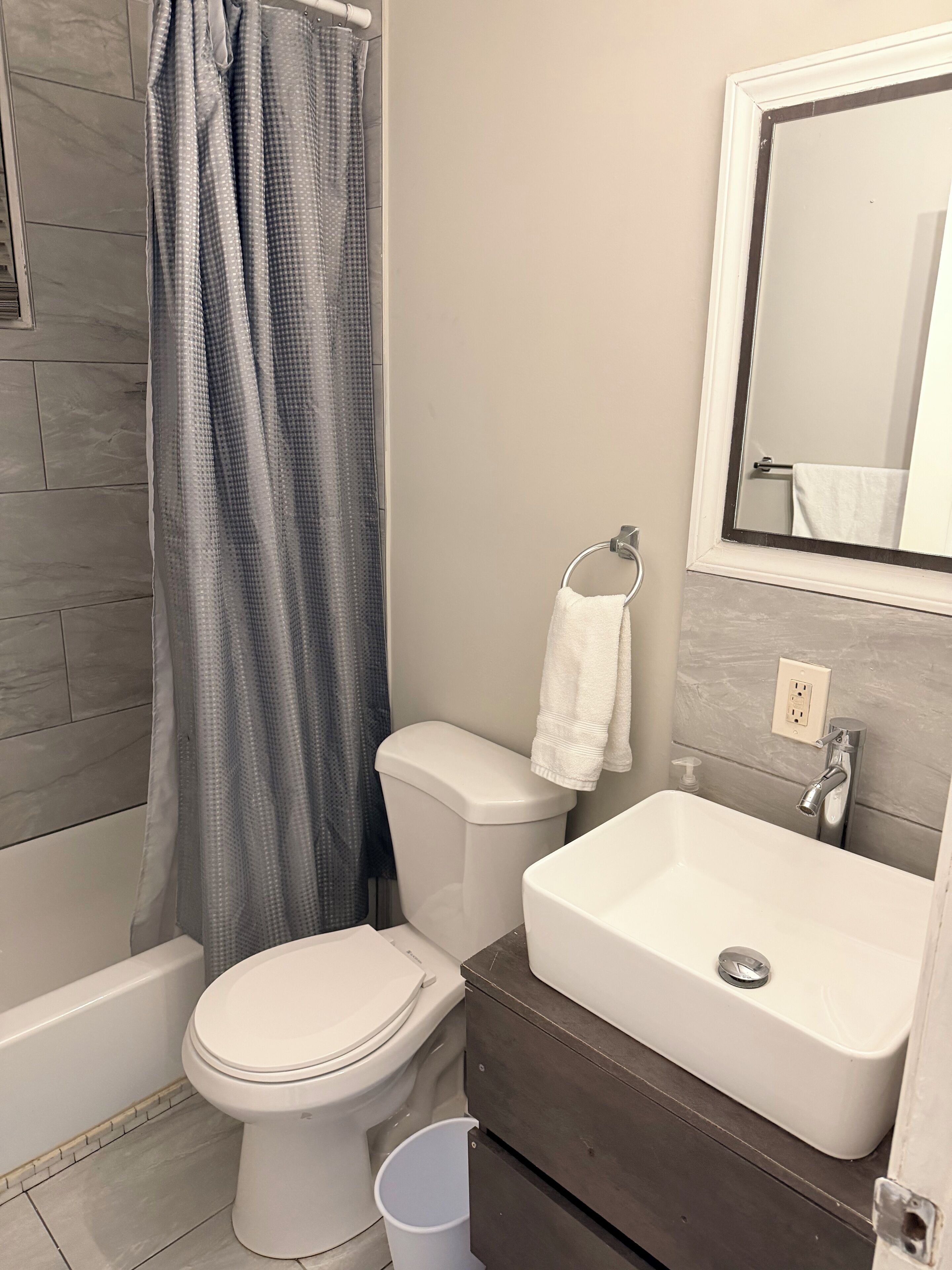 A bathroom with a toilet, sink, and shower curtain.