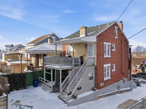 Un immeuble résidentiel doté d’un porche, d’un escalier et d’une façade en briques.