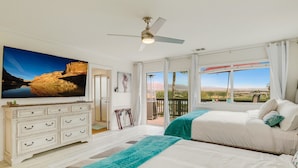 A bedroom with two beds, a TV, a ceiling fan, and a balcony with a view. - Golf, Lake & Mountain Views, Pool, Spa, BBQ, Games (Indio)