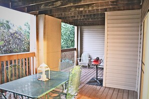 A covered patio with a metal table and chairs, a lantern, and a red grill. - Branson Condo next to Silver Dollar City (Indian Point)