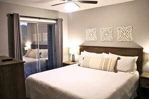 A hotel room with a large bed, a ceiling fan, and a view through a sliding door to the outside. - Branson Condo next to Silver Dollar City (Indian Point)