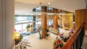 A spacious lobby with a high ceiling, large windows, and a modern staircase. - Elegance Ninh Binh Hotel  (Ninh Binh)