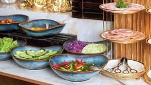 A buffet setup with various dishes and a decorative golden birdcage centerpiece. - Elegance Ninh Binh Hotel  (Ninh Binh)