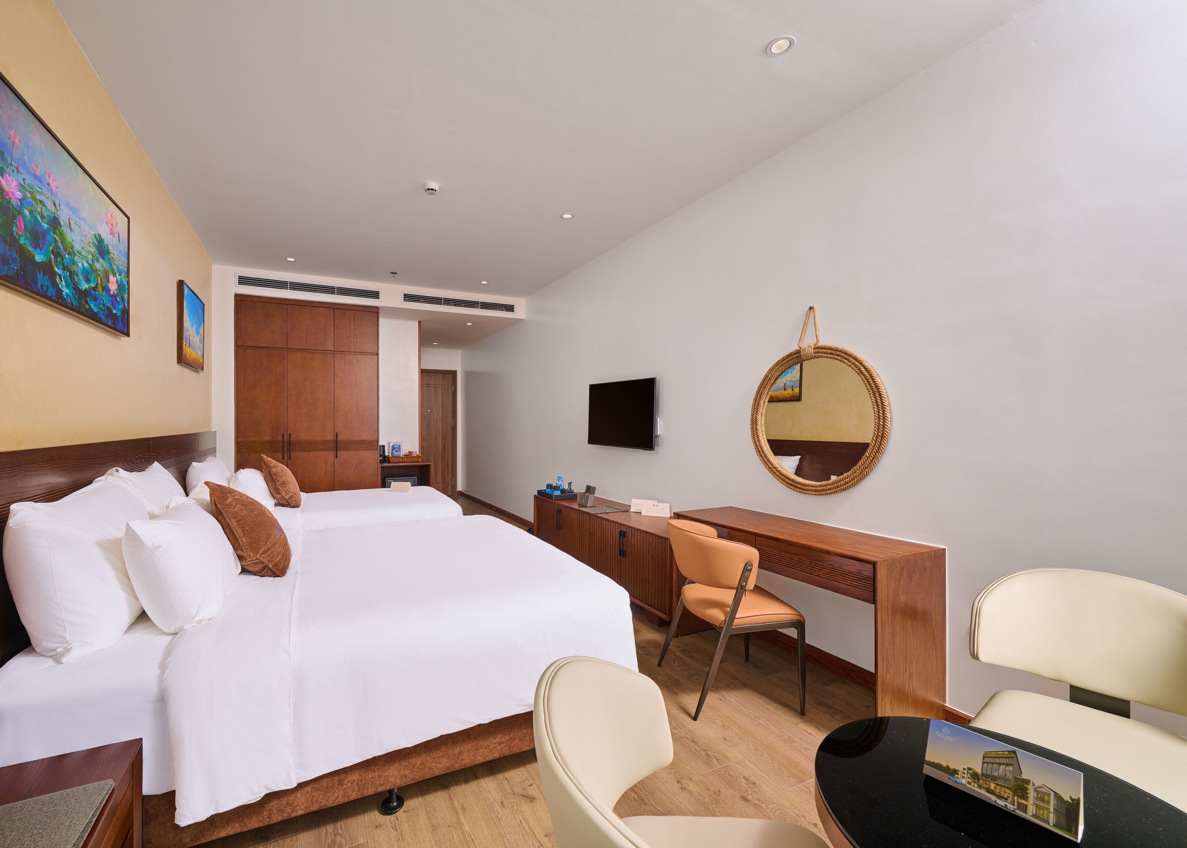 A hotel room with a large bed, a desk, a chair, a television, and a mirror.