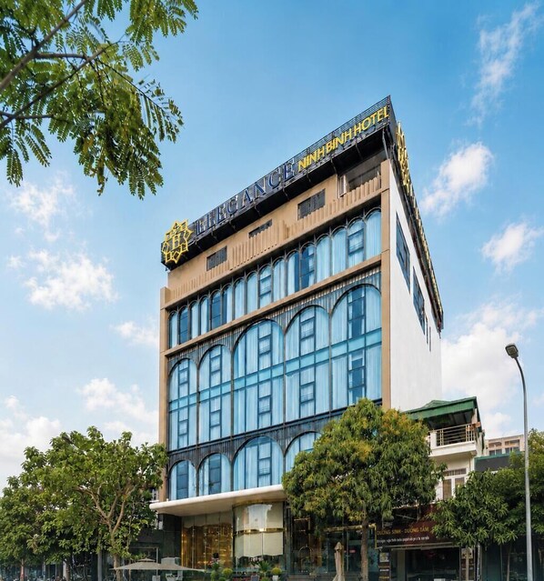 A modern hotel building with a prominent sign, large windows, and a flat roof. - Elegance Ninh Binh Hotel  (Ninh Binh)