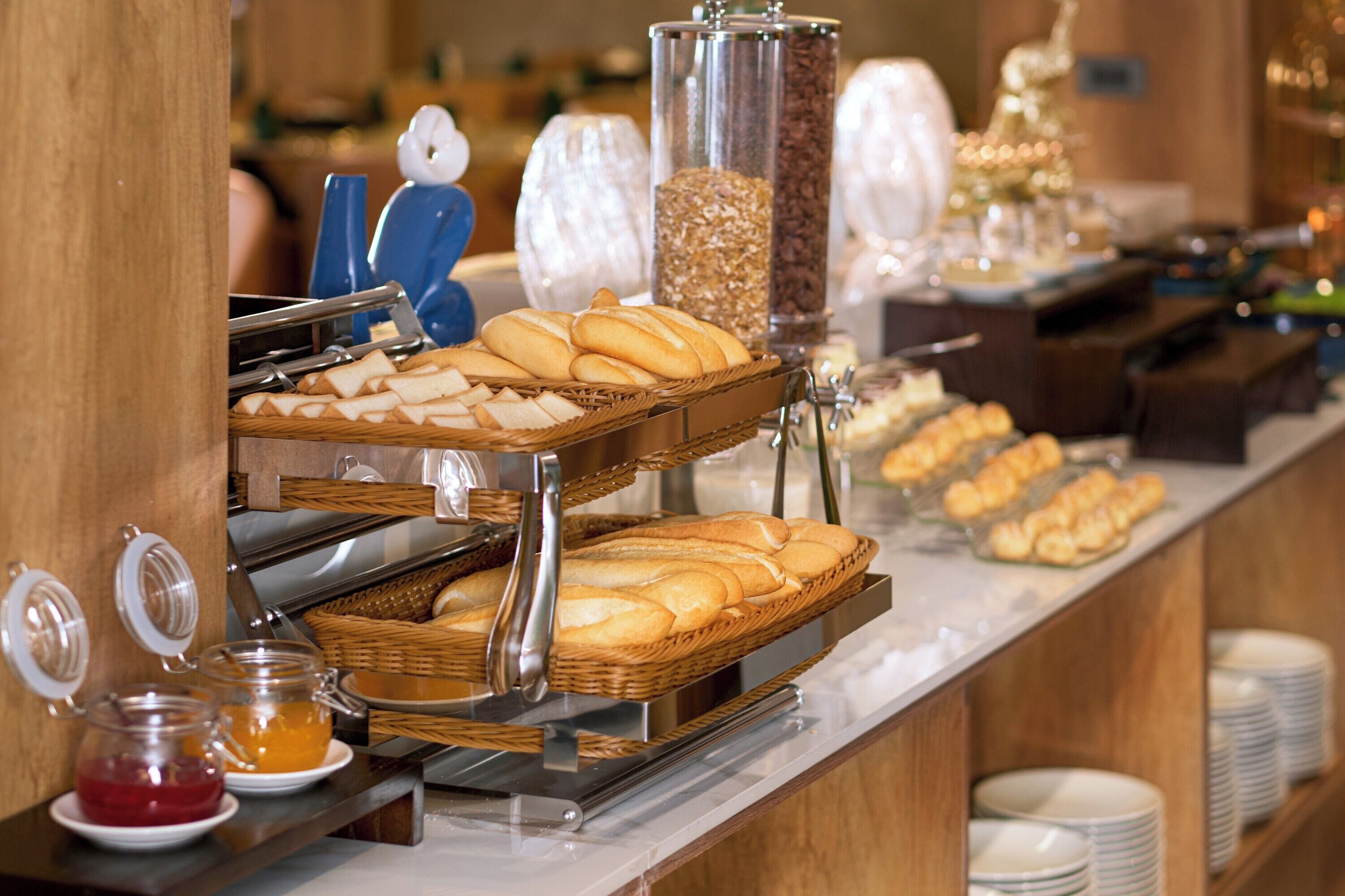 A buffet with various food items, including bread and pastries, arranged on a counter.