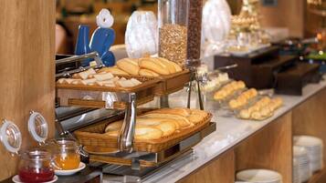 A buffet with various food items, including bread and pastries, arranged on a counter.