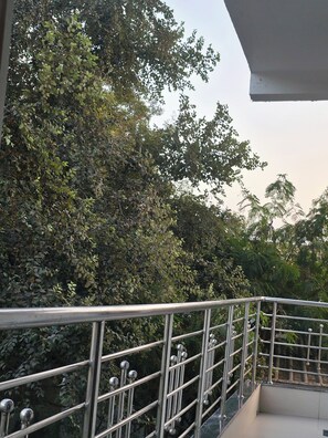 A balcony with a metal railing overlooking dense foliage. - Ekaay The Boutique Hotel (Rajagangapur)