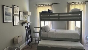 A bunk bed room with a ladder, a shelf with books, and framed pictures on the wall. - Terrific 4-bedroom house in charming West Point (West Point)