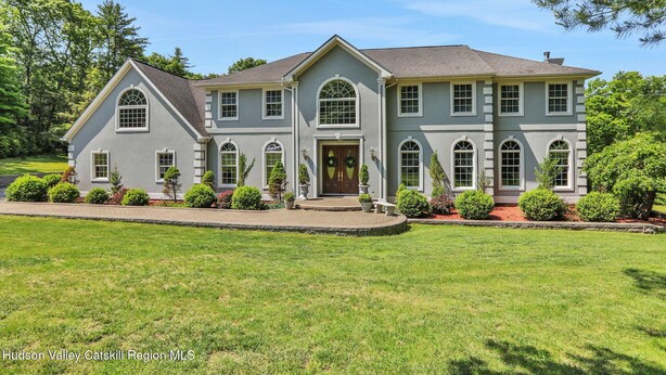 A large, two-story house with a symmetrical facade, multiple windows, and a well-maintained lawn. - Spacious 7-bedroom country house in perfect Kingston retreat (Kingston)