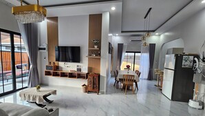 Un salon moderne équipé d’un téléviseur, de sièges et d’un coin repas.
