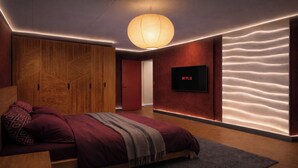A modern bedroom with a bed, a TV, and a unique wall design. - Crimson Autumn - Nordic Suite (Aalborg)