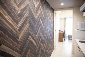 A modern kitchen with a herringbone-patterned backsplash, a microwave, and a sink. - izumi kuzyo (Osaka)