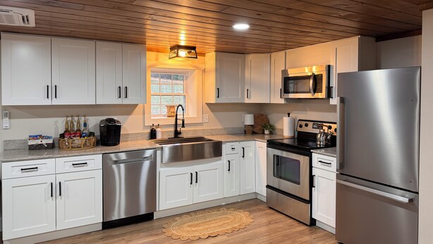 A modern kitchen with white cabinets, stainless steel appliances, and a wooden ceiling. - Relaxing Farmhouse in beautiful Butler (Butler)