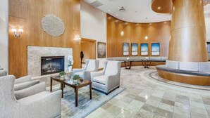 Een moderne lobby met een open haard, een zithoek en kunstwerken aan de wanden.