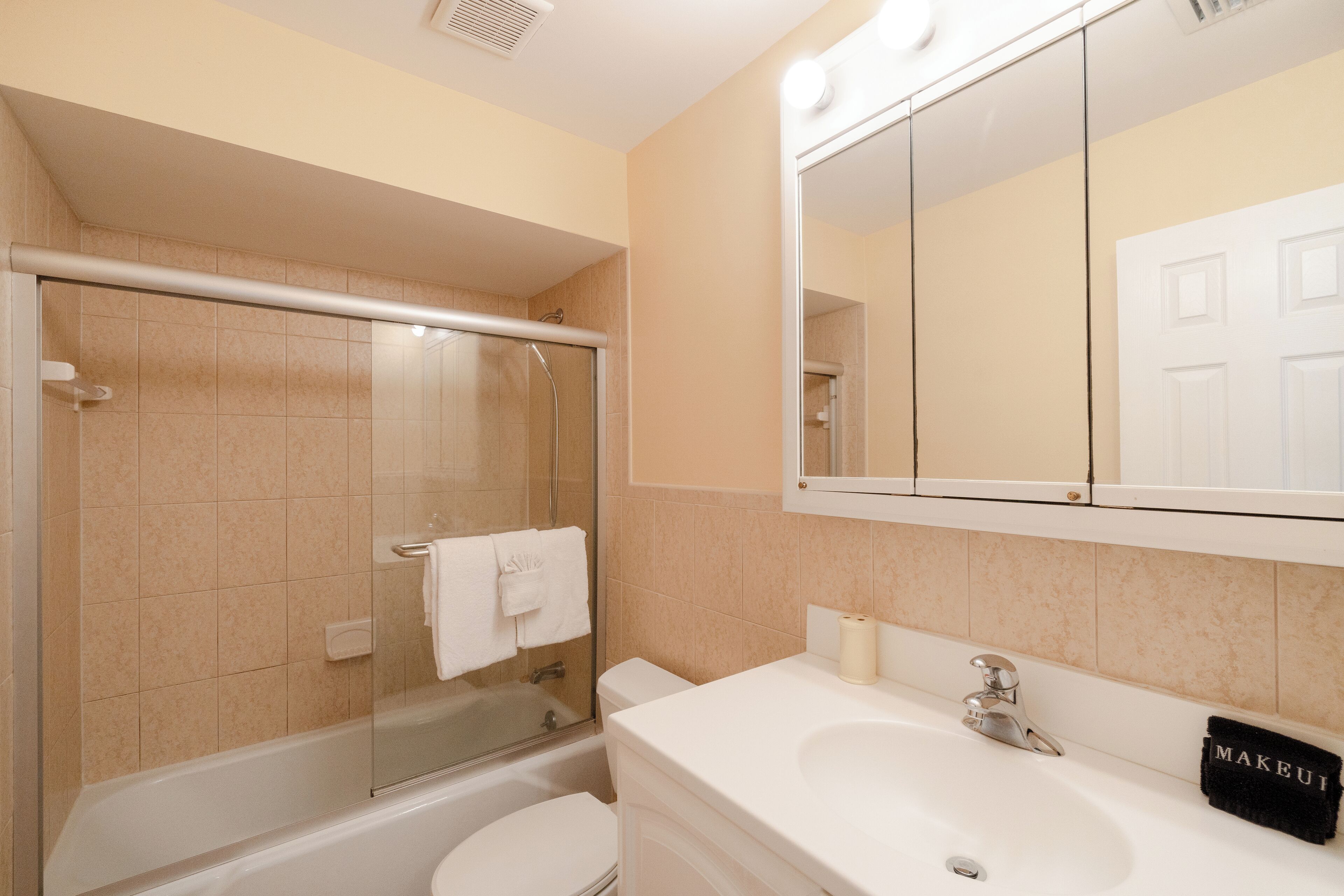 A bathroom with a bathtub, toilet, and sink.