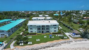 A resort with a pool, beach, and multiple buildings. - Key Colony Beach oceanview condo, beach + heated pool (Key Colony Beach)