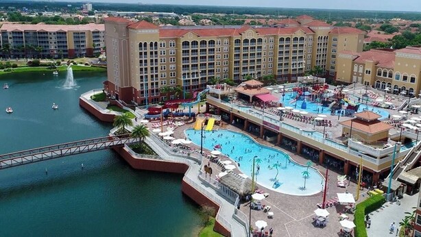 Ein Hotel mit großem Pool, Wasserpark und einer Brücke über dem Wasser.