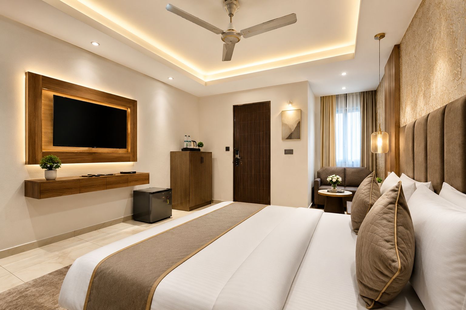 Una habitación de hotel moderna con una cama grande, un televisor de pantalla plana, un minibar y un ventilador de techo.