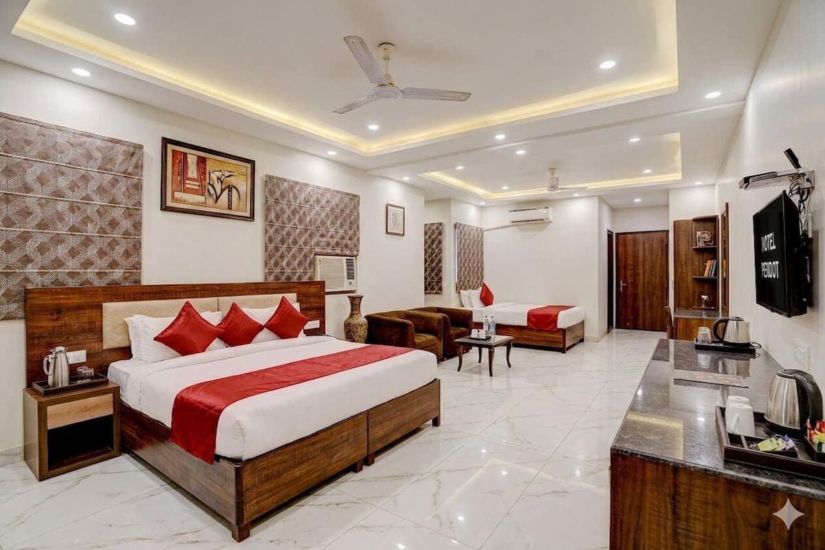A hotel room with a large bed, a desk, a chair, and a TV.