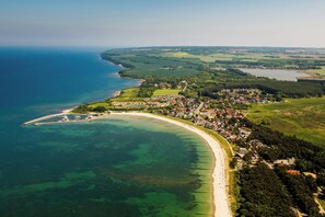 An aerial view of a coastal town with a beach, residential areas, and a marina. - Wellenbrecher Vacation Home—PRIME LOCATION with sauna, hot tub, fireplace, Wi-Fi, and Wii (Glowe)