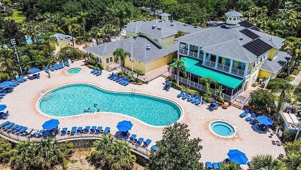 A resort with a large swimming pool, multiple lounge areas, and a view of the surrounding landscape. - Designer-Renovated Condo in a Gorgeous Tropical Oasis! (Davenport)