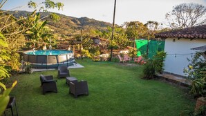 A backyard with a hot tub, outdoor seating, and a view of hills. - Casa San Isidro is a sparkling clean, and family friendly house (Copán Ruinas)