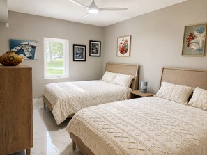 A bedroom with two beds, a wooden dresser, and artwork on the walls. - Okoboji Waterfront 5BR• Private Dock, Boat Slip, Kayaks & Paddleboards (Arnolds Park)