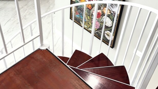A wooden staircase with a white railing, leading to a room with a framed floral painting on the wall. - Waterfront Arnolds Park 4BR Dock, Boat Slip, Kayaks & Paddleboards (Arnolds Park)