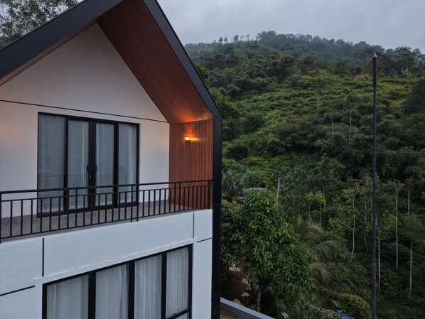 A modern building with a balcony overlooking a lush, green hillside. - Anemos Resort By Tamastu (Cijeruk)
