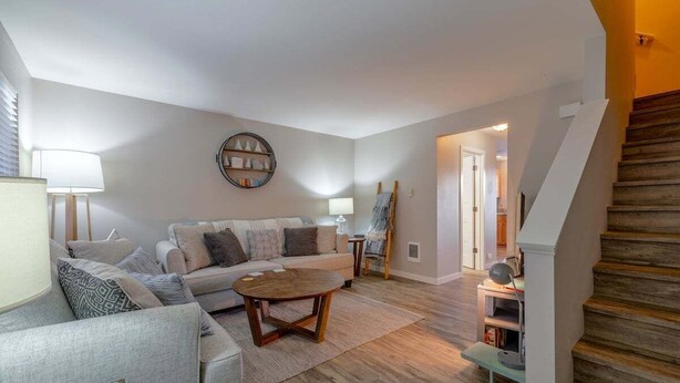Ein Wohnzimmer mit einer Couch, einem Couchtisch und einer Treppe.