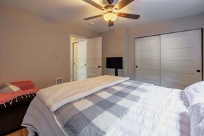 A bedroom with a bed, a ceiling fan, a TV, and two closets. - Yodel Haus -  A Walkable Leavenworth Stay (Leavenworth)