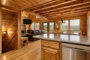 L’intérieur d’un chalet en bois comprend une cuisine, un coin repas et un salon.