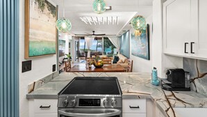 A modern kitchen with a built-in stove, oven, and a dining area with a view of the ocean.