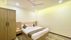 A modern bedroom with a bed, wooden wardrobe, and a ceiling fan. - P R Palace -near Temple & Prime Location (Ujjain)