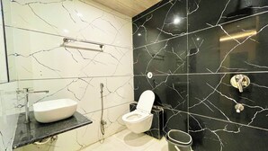 A modern bathroom with a white sink, toilet, and shower. - P R Palace -near Temple & Prime Location (Ujjain)