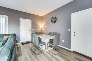 A compact living space with a dining table, four chairs, a sofa, and a door. - Game, Stay & Play: Family Home in Westland! (Westland)