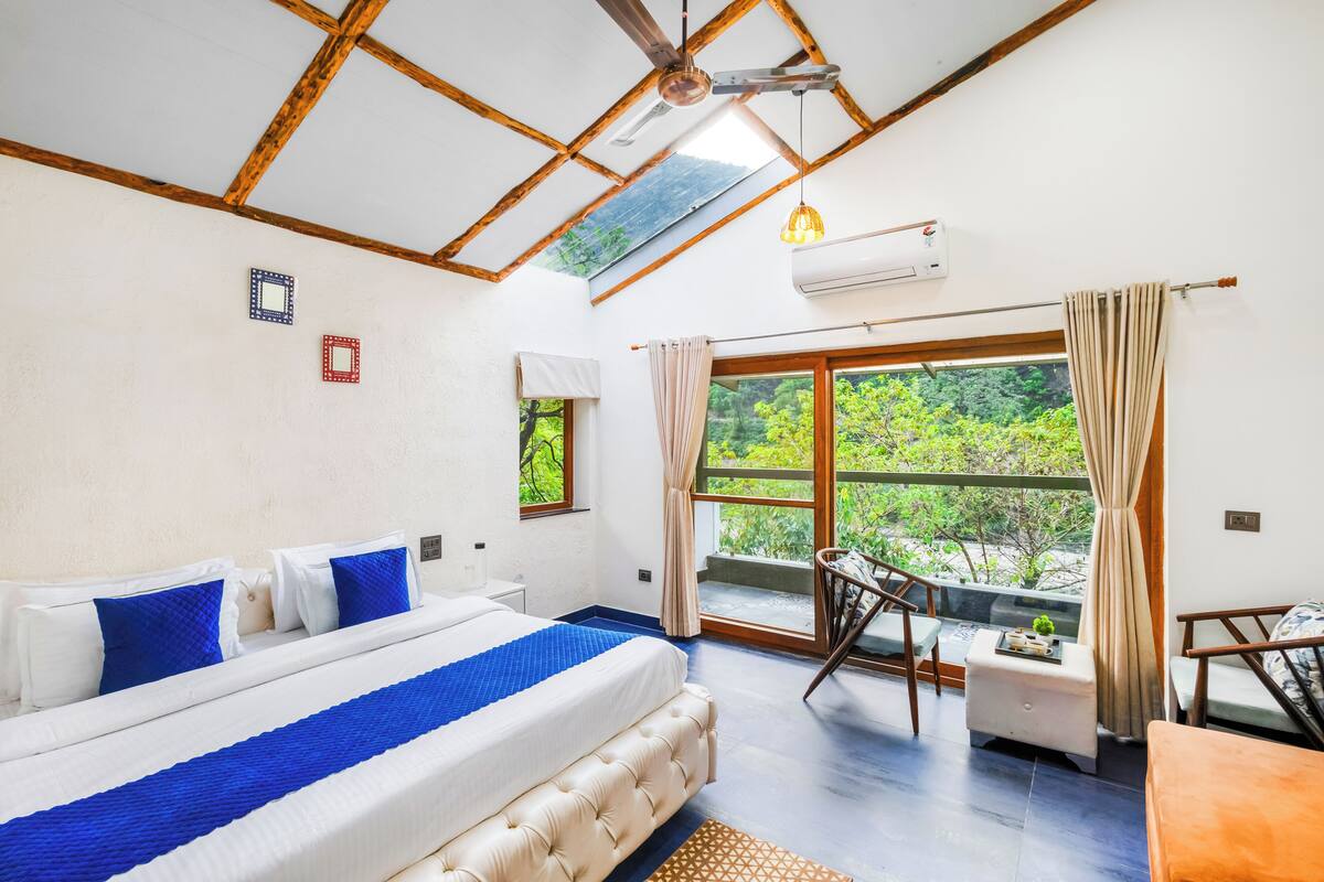 A bedroom with a bed, a window, a balcony, and a ceiling fan.