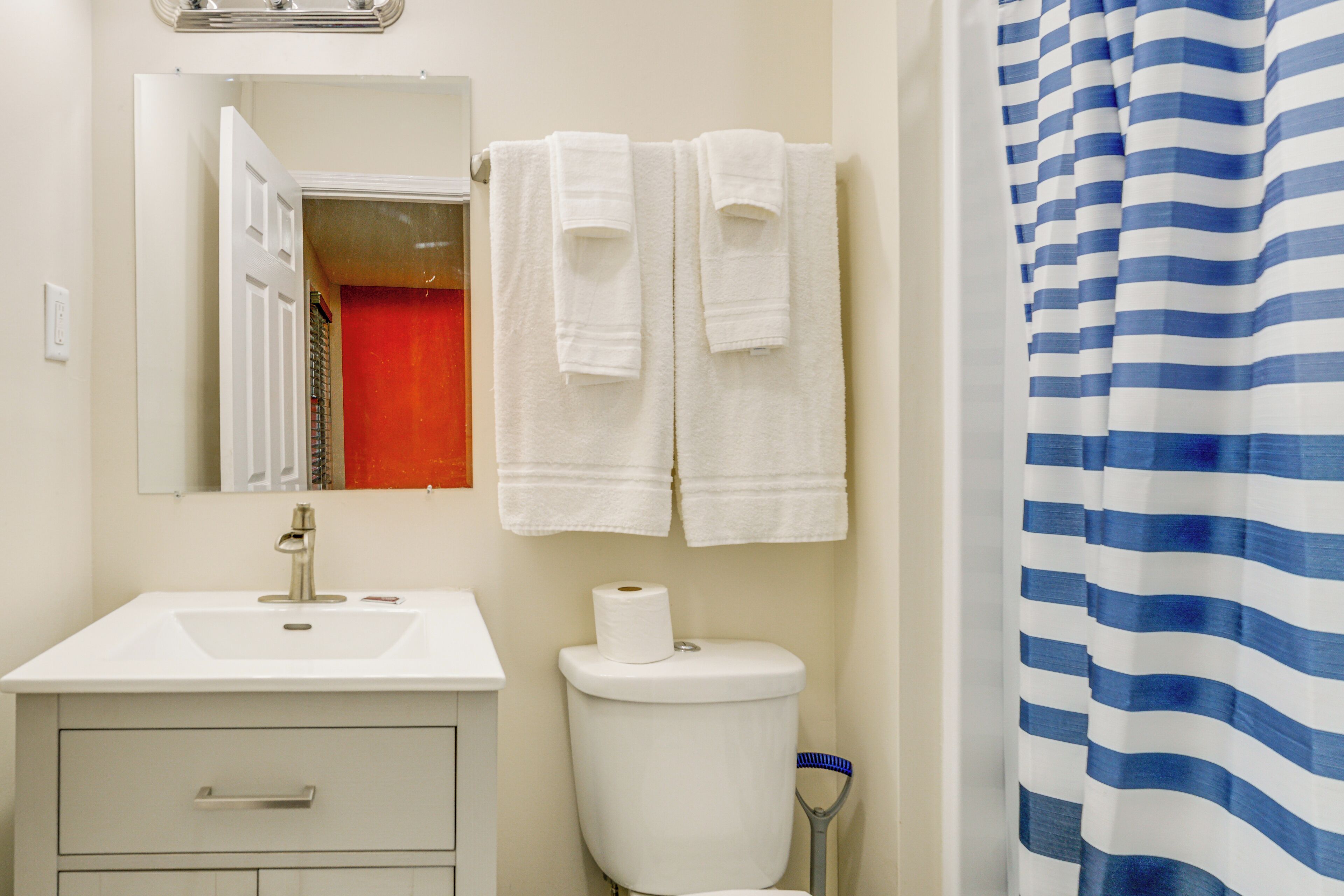 A bathroom with a white sink, a toilet, and a shower curtain.